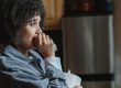 lady crying in kitchen whilst hold a tissue box