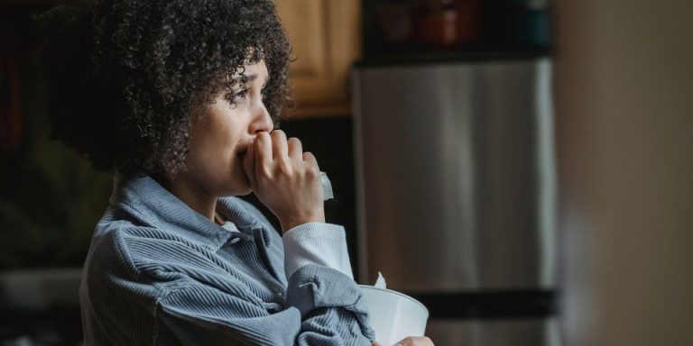 lady crying in kitchen whilst hold a tissue box