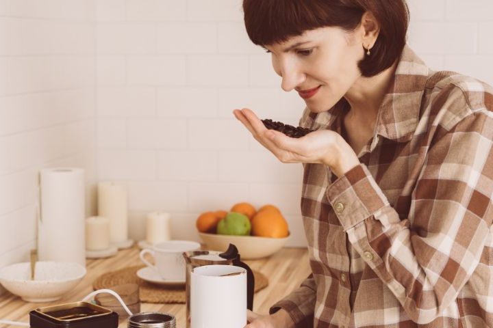 lady smelling coffee beans in her hand